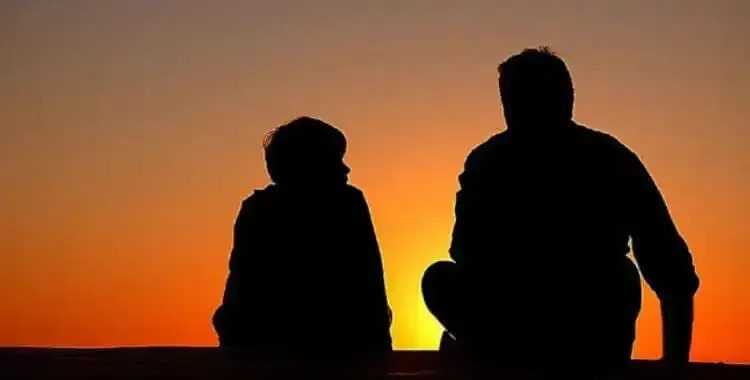 Siluetas de un padre y un hijo al atardecer