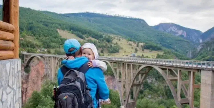 Un padre abrazando a su hijo con un puente en frente