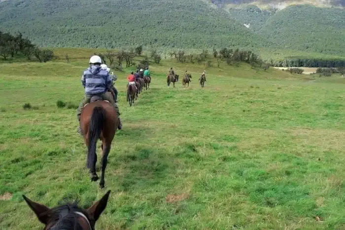 Gente montando a caballo en una llanura