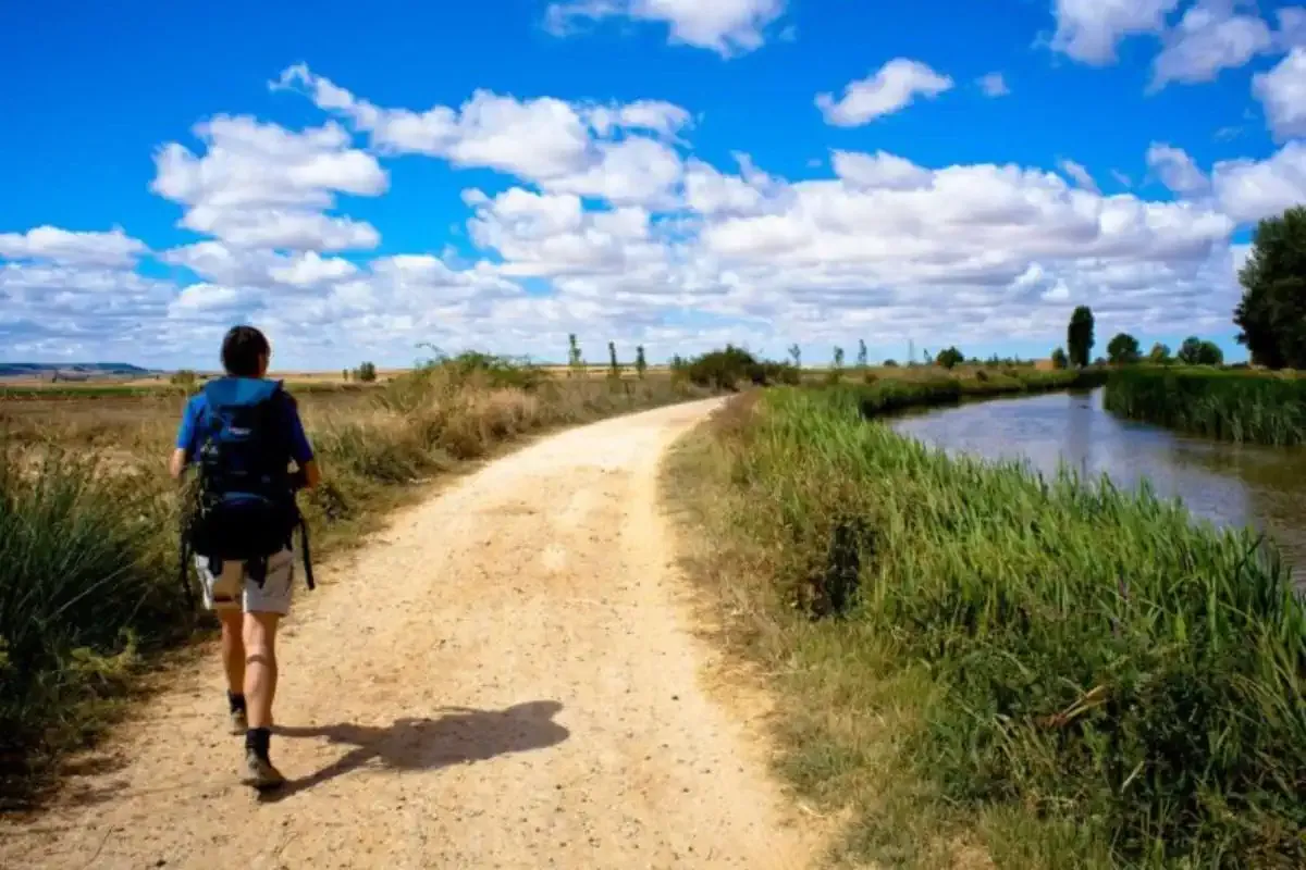 Peregrino con mochila haciendo el Camino de Santiago en verano