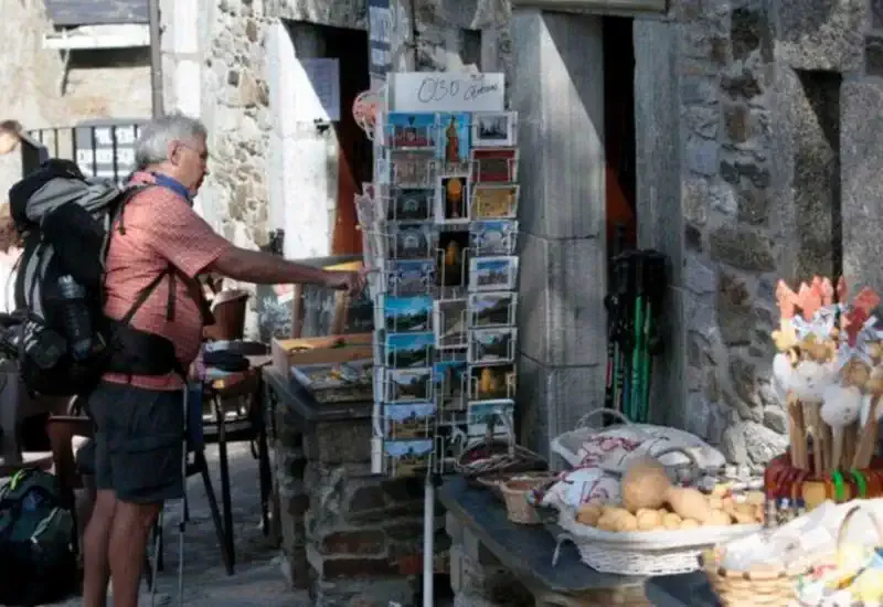 Un peregrino comprando postales