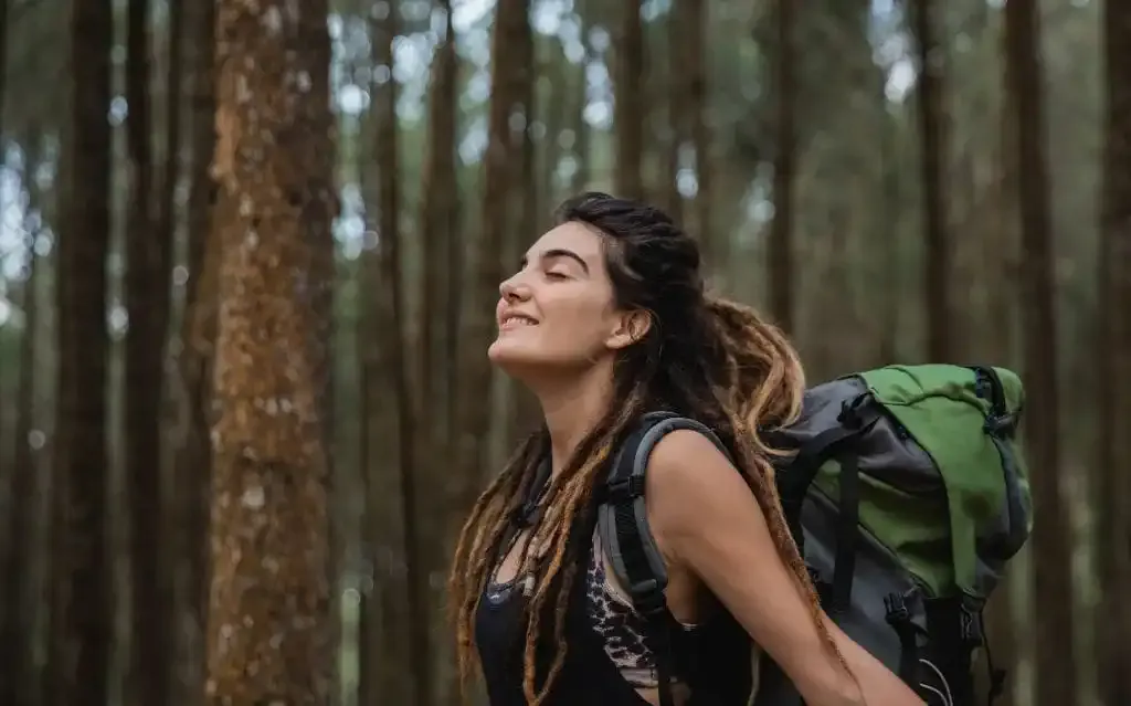 Una mujer respirando el aire del bosque