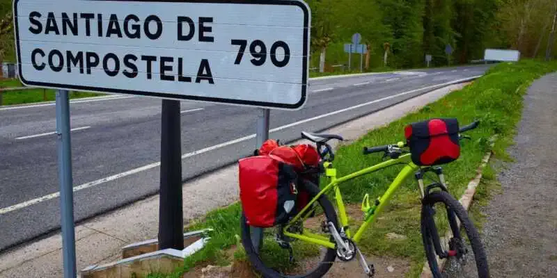 Una bici apoyada en un letrero a Santiago